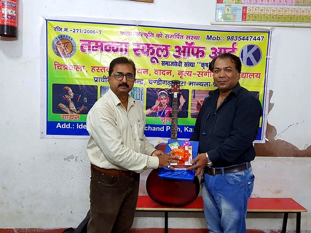 A man being felicitated with a shawl by volunteers