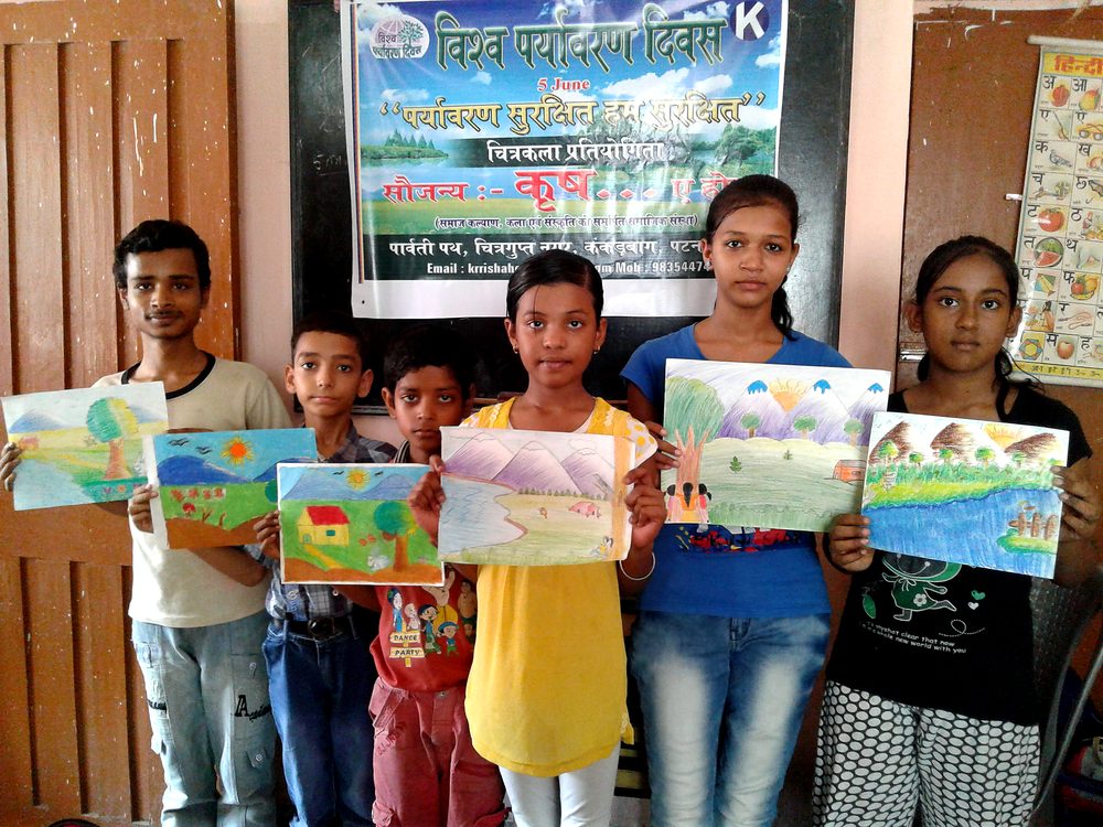 Children of KRRISH holding up the paintings they made in class